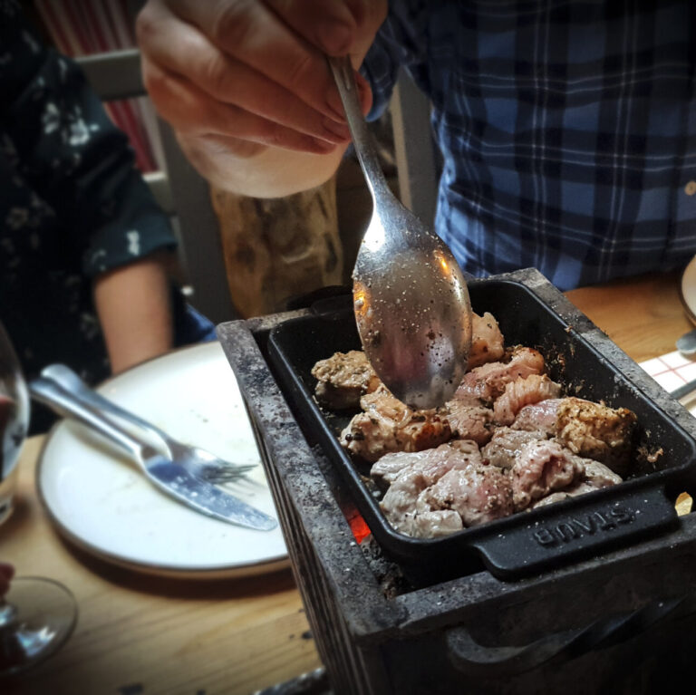 Grilling av kjøtt på ein av bordgrillane på låven.