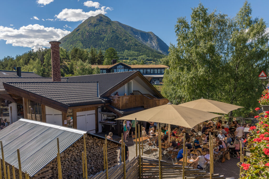 Uteserveringa ved Bakeriet i Lom ein varm sommardag. Mykje folk.